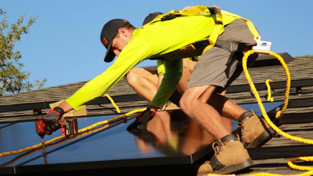 Solar battery installers working on a residential rooftop in NSW